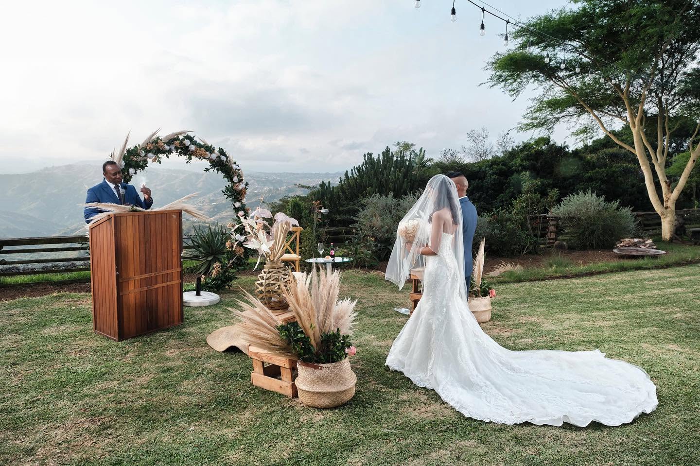 Vows read at a timber lectern beside a circular floral arch