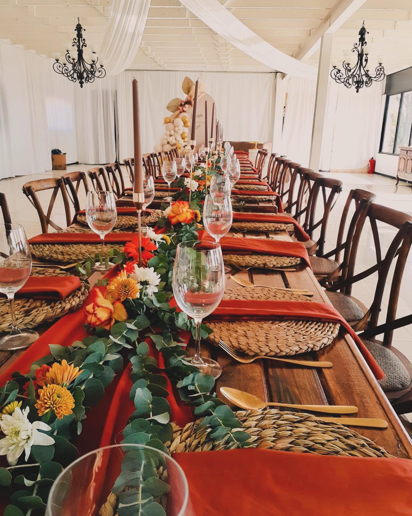 Indoor table set with terracotta linen, eucalyptus and taper candles