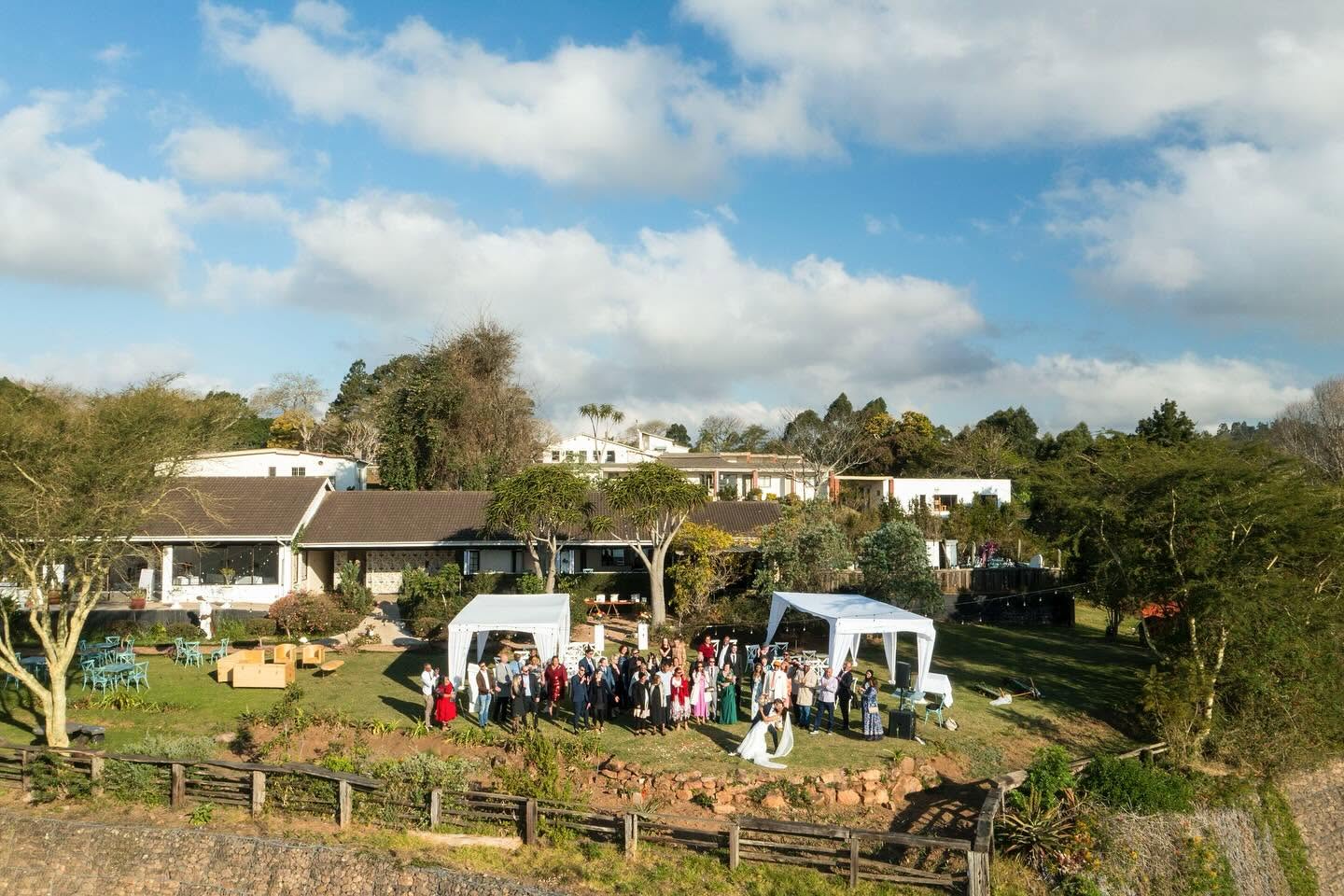 Aerial view of the estate lawn with guests gathered below the house