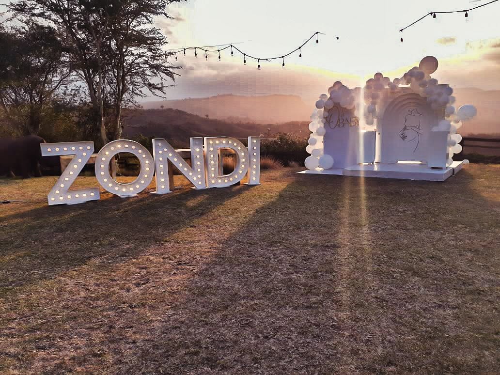 Illuminated marquee letters and balloon arch at sunset