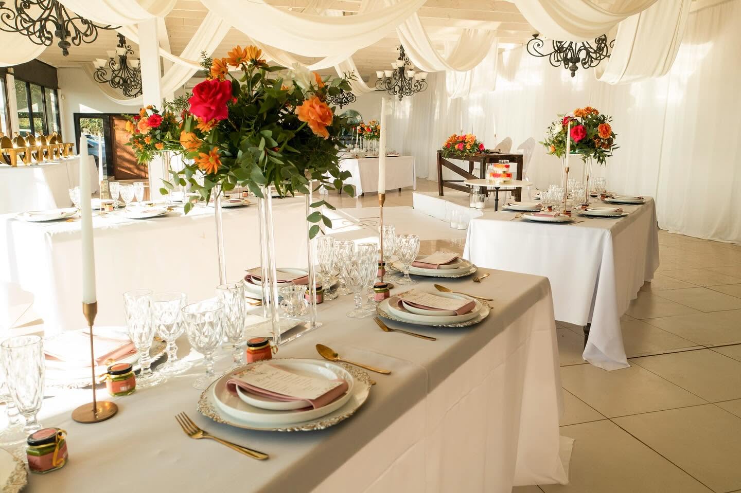 Draped indoor hall with citrus florals and gold cutlery